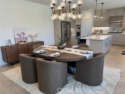 dining room featuring light wood-type flooring and a chandelier