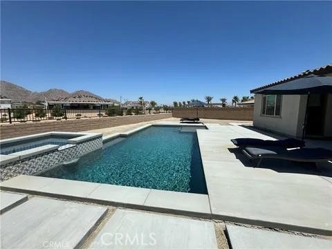 view of swimming pool featuring an in ground hot tub and a mountain view