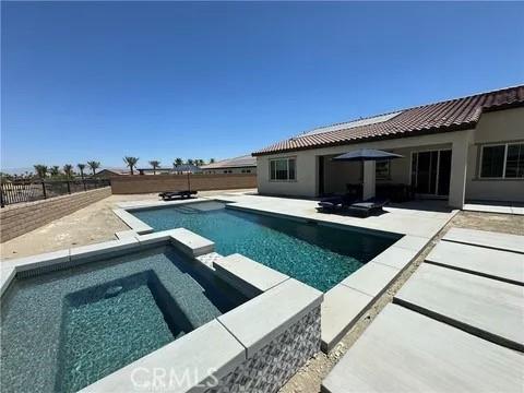 view of swimming pool featuring a patio area and an in ground hot tub