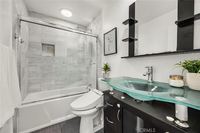 full bathroom with vanity, tiled shower / bath combo, wood-type flooring, and toilet