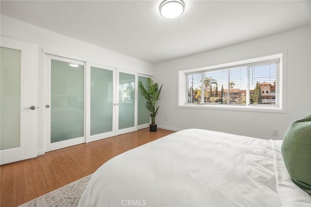 bedroom with hardwood / wood-style flooring, two closets, and french doors