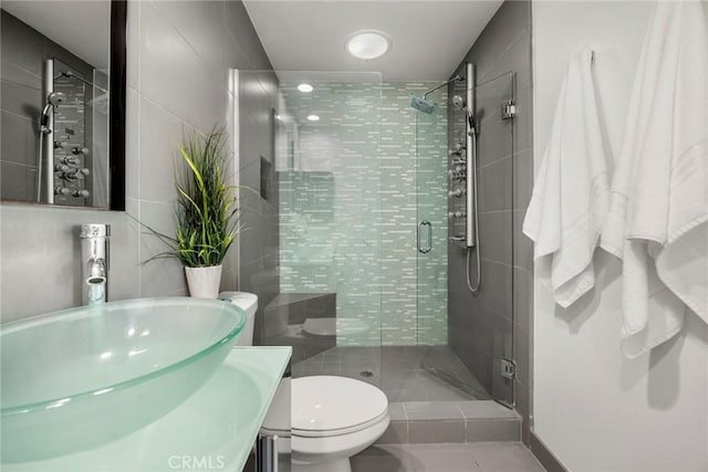 bathroom with vanity, tile walls, an enclosed shower, and toilet