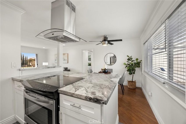 kitchen featuring white cabinetry, dark hardwood / wood-style floors, island exhaust hood, stainless steel range with electric cooktop, and kitchen peninsula