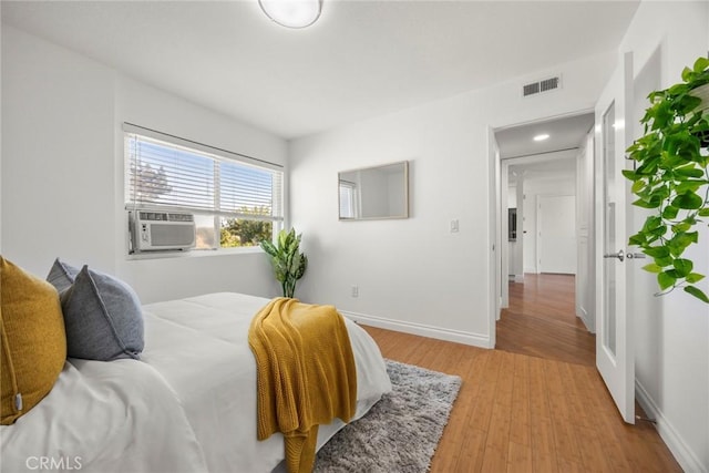 bedroom featuring cooling unit and light wood-type flooring