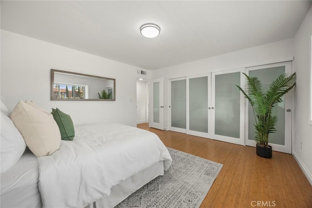 bedroom featuring hardwood / wood-style flooring and two closets