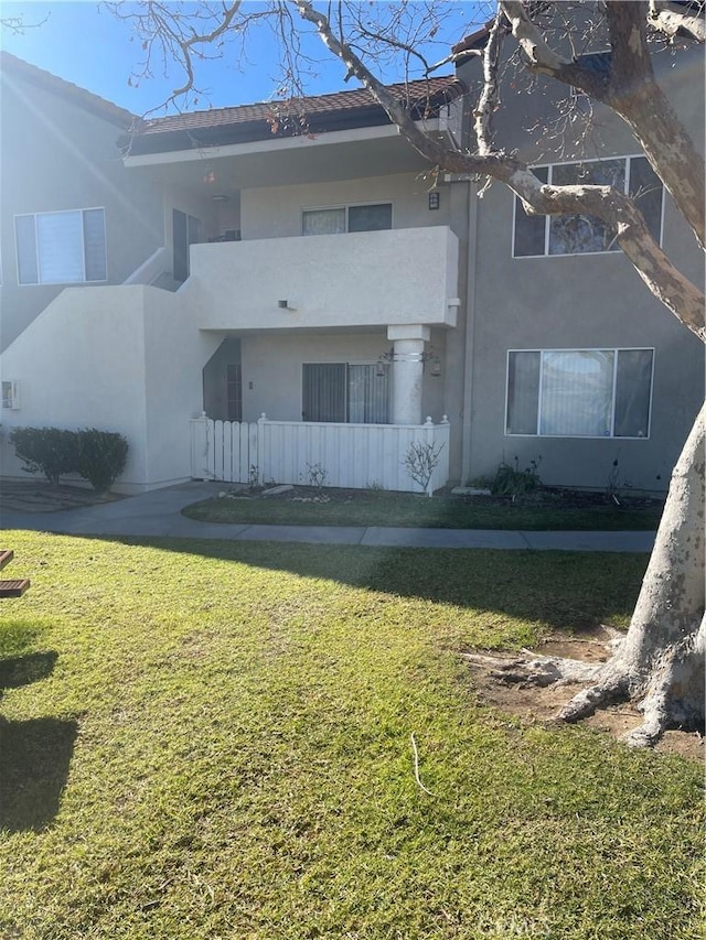 exterior space with a balcony and a yard