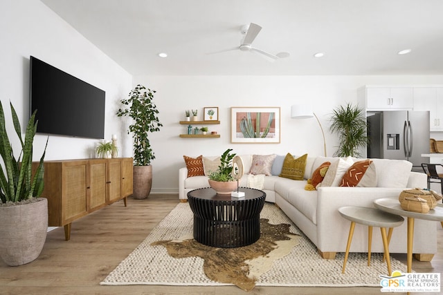 living room featuring ceiling fan and light hardwood / wood-style flooring