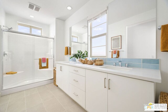 bathroom featuring a shower with shower door, vanity, and tile patterned flooring