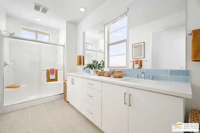 bathroom featuring tile patterned flooring, a shower with door, and vanity