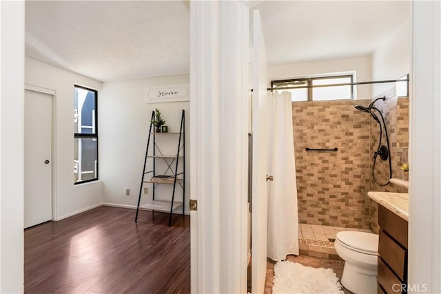 bathroom with hardwood / wood-style floors, toilet, vanity, and a shower with shower curtain