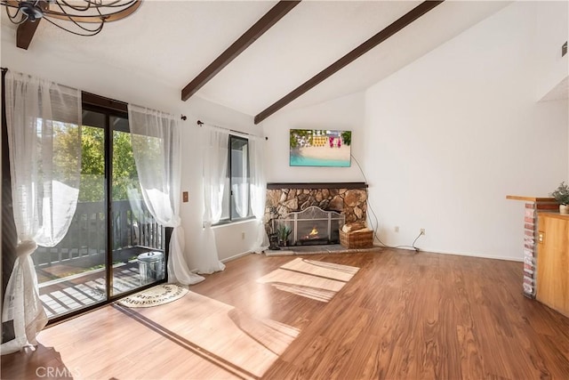 unfurnished living room featuring high vaulted ceiling, hardwood / wood-style floors, beam ceiling, and a fireplace