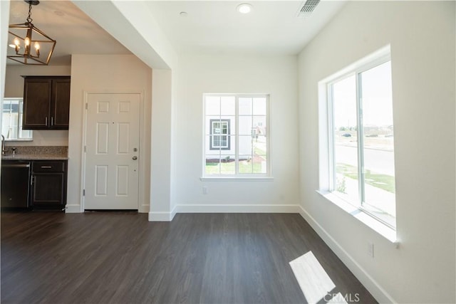 interior space featuring plenty of natural light, dark hardwood / wood-style flooring, and a chandelier