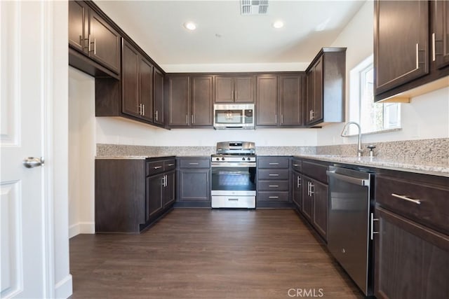 kitchen featuring dark brown cabinets, sink, light stone counters, and stainless steel appliances