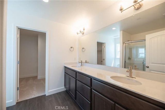 bathroom featuring walk in shower, vanity, and hardwood / wood-style flooring