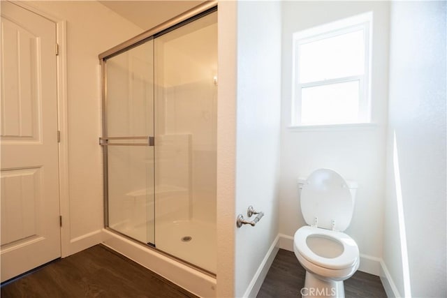 bathroom featuring a shower with shower door, wood-type flooring, and toilet