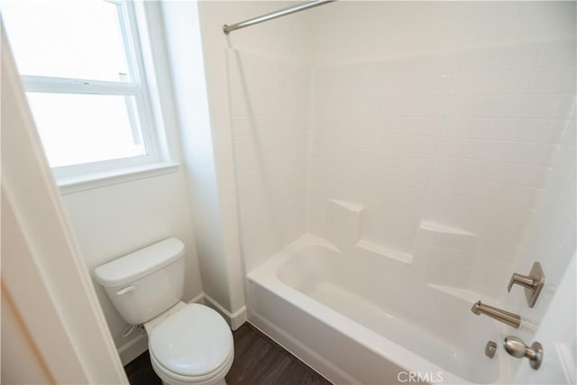 bathroom with toilet, wood-type flooring, and washtub / shower combination