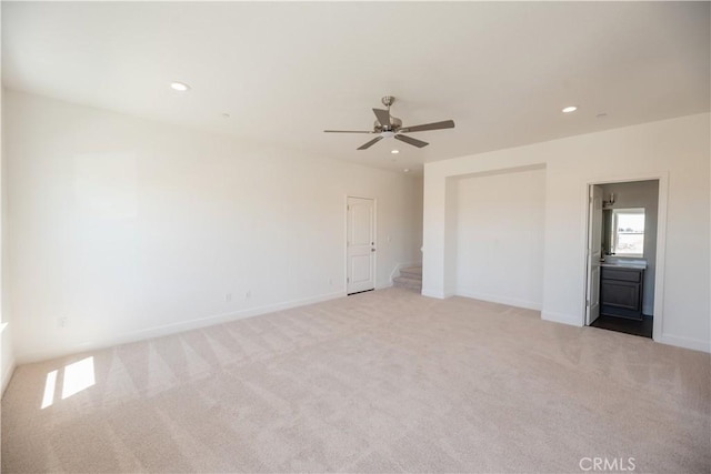 unfurnished bedroom featuring ceiling fan, connected bathroom, and light colored carpet