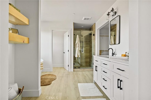 bathroom featuring a shower with door, vanity, and wood-type flooring