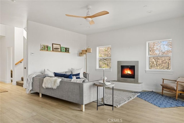 living room with light hardwood / wood-style flooring and ceiling fan