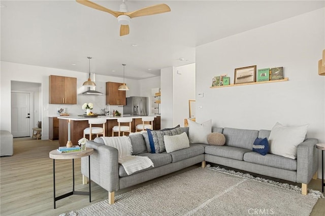 living room featuring ceiling fan and light wood-type flooring