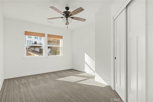 unfurnished bedroom featuring light colored carpet, a closet, and ceiling fan