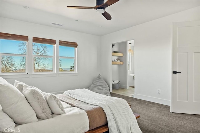 carpeted bedroom with ceiling fan and ensuite bath