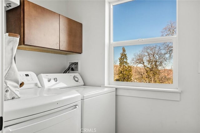 laundry area featuring separate washer and dryer and cabinets