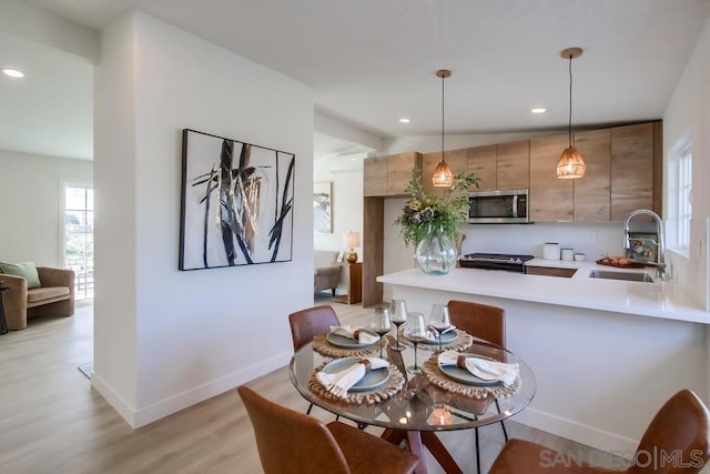 dining space featuring sink and light hardwood / wood-style flooring