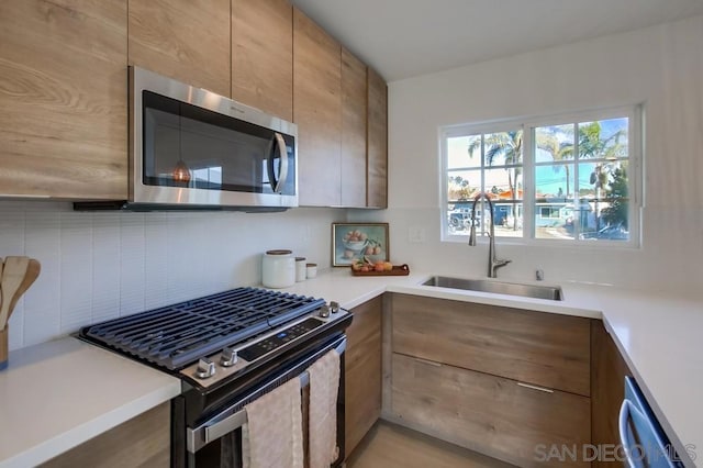 kitchen featuring stainless steel appliances, sink, and backsplash