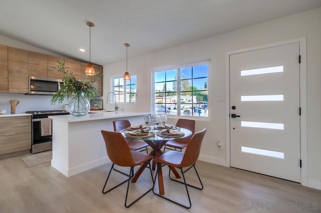 dining room featuring sink and light hardwood / wood-style floors