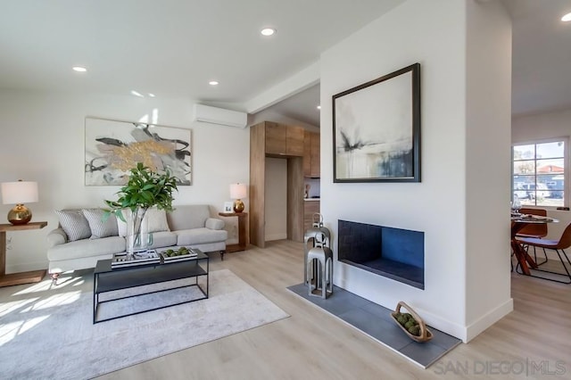 living room with lofted ceiling, a wall unit AC, and light hardwood / wood-style floors