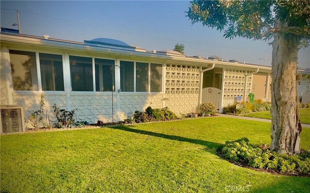 ranch-style house featuring a front lawn and central AC unit