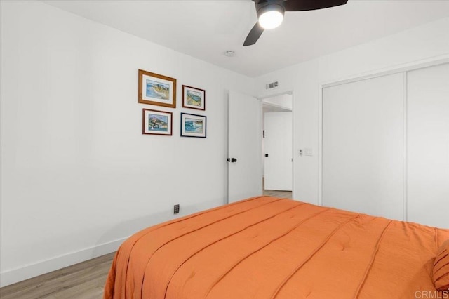 bedroom with ceiling fan, a closet, and light wood-type flooring