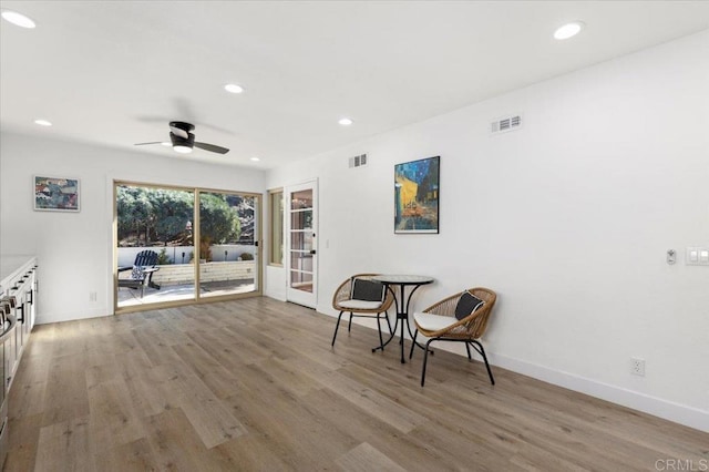 living area with light wood-type flooring and ceiling fan