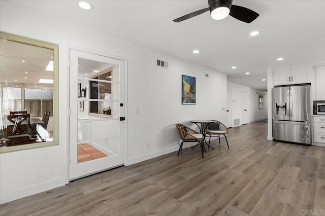 kitchen featuring appliances with stainless steel finishes, hardwood / wood-style flooring, white cabinetry, and ceiling fan