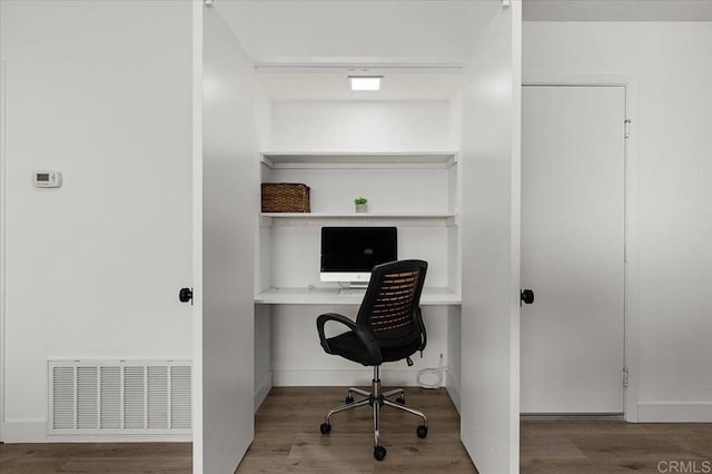 home office with hardwood / wood-style floors and built in desk