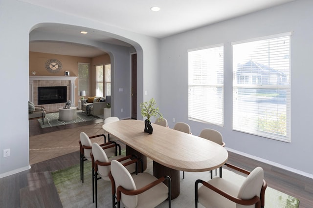 dining space featuring a wealth of natural light, a fireplace, and dark hardwood / wood-style flooring