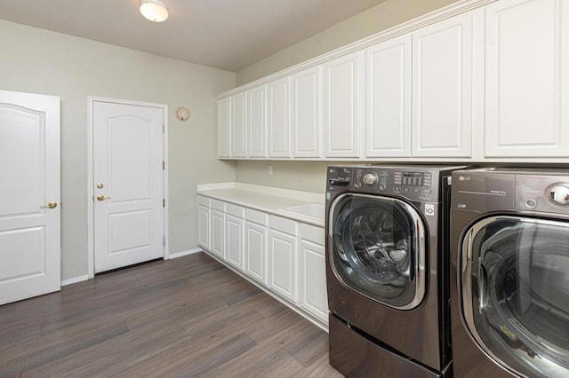 laundry area with cabinets, dark hardwood / wood-style floors, and washing machine and dryer