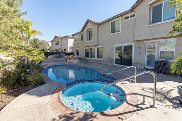 view of pool with central AC, a patio, and an in ground hot tub