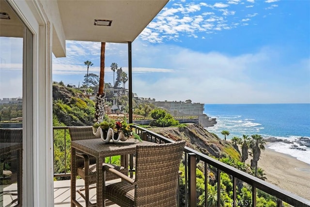 balcony featuring a water view and a beach view