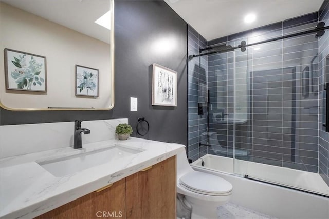 full bathroom with bath / shower combo with glass door, toilet, and vanity