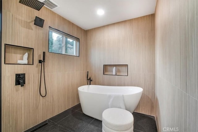 bathroom with tile walls, tile patterned floors, and plus walk in shower