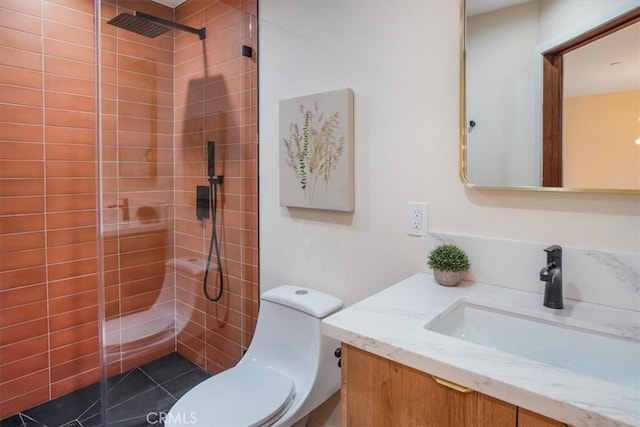 bathroom with toilet, vanity, tile patterned flooring, and tiled shower