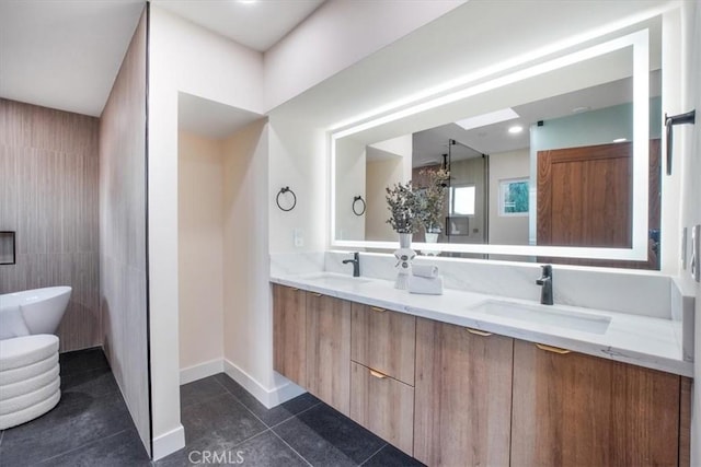 bathroom with a tub, vanity, and tile patterned flooring