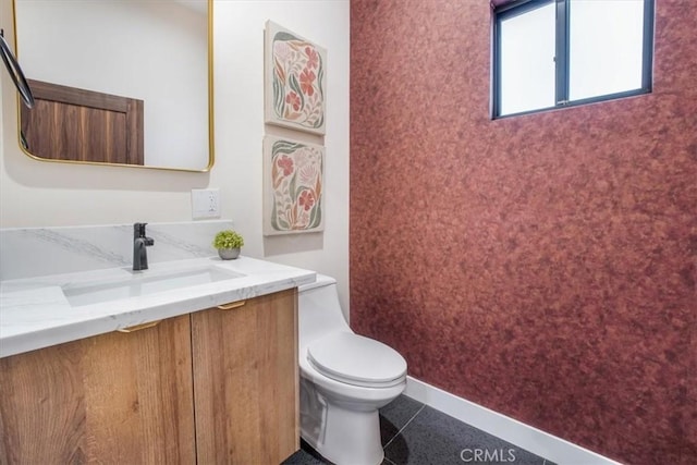 bathroom with toilet, vanity, and tile patterned flooring