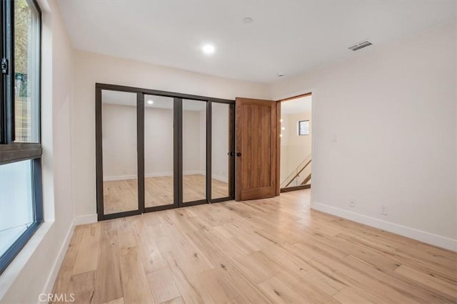 unfurnished room with light wood-type flooring and a healthy amount of sunlight