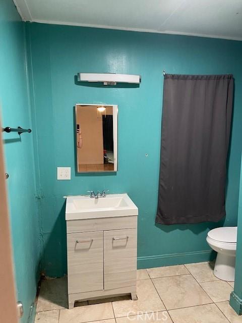 bathroom with toilet, tile patterned floors, and vanity