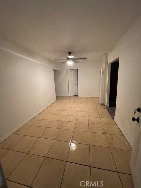 tiled spare room featuring ceiling fan