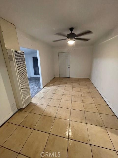 tiled empty room featuring ceiling fan