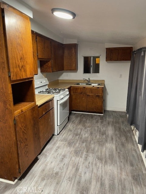 kitchen featuring light hardwood / wood-style flooring, sink, and white range with gas cooktop